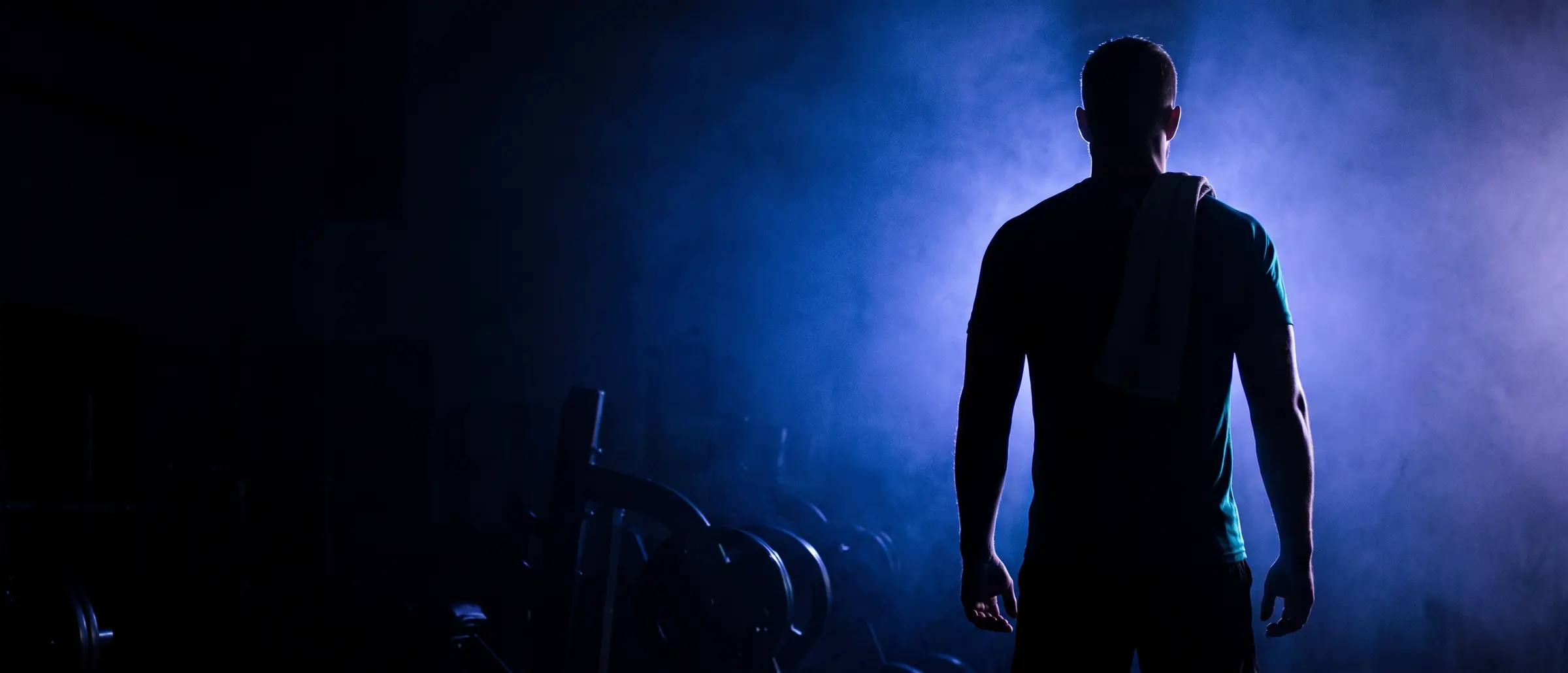 Silhouette of an athlete backlit by blue light at the end of a session