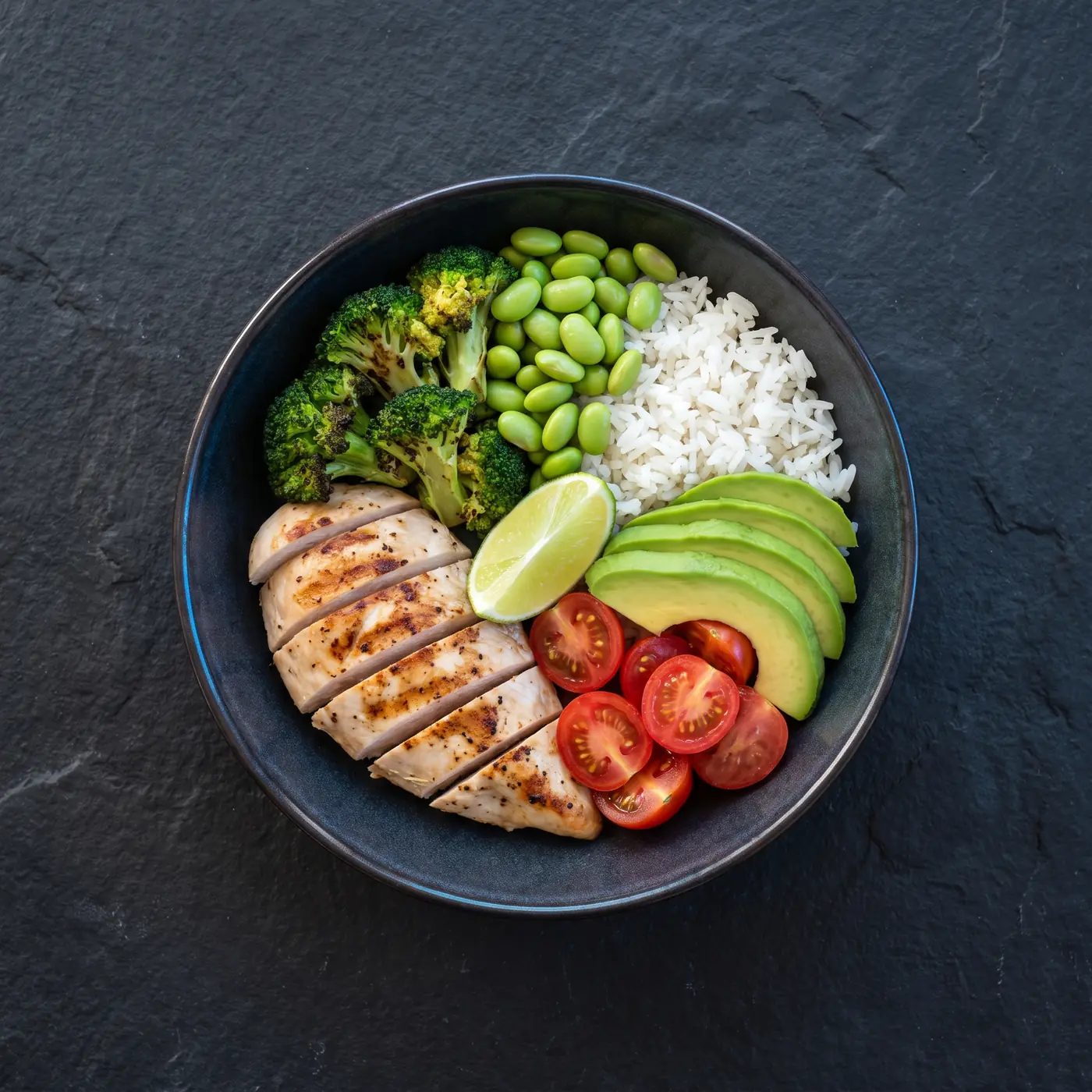 Overhead shot of a high-protein bowl with grilled chicken, rice and vegetables