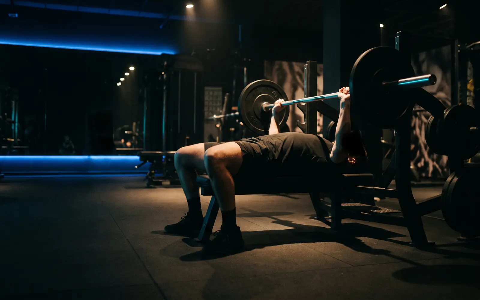 Athlete performing a heavy barbell lift in a dark gym